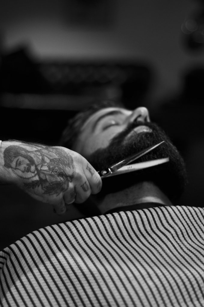 Un client se fait tailler la barbe par un barber