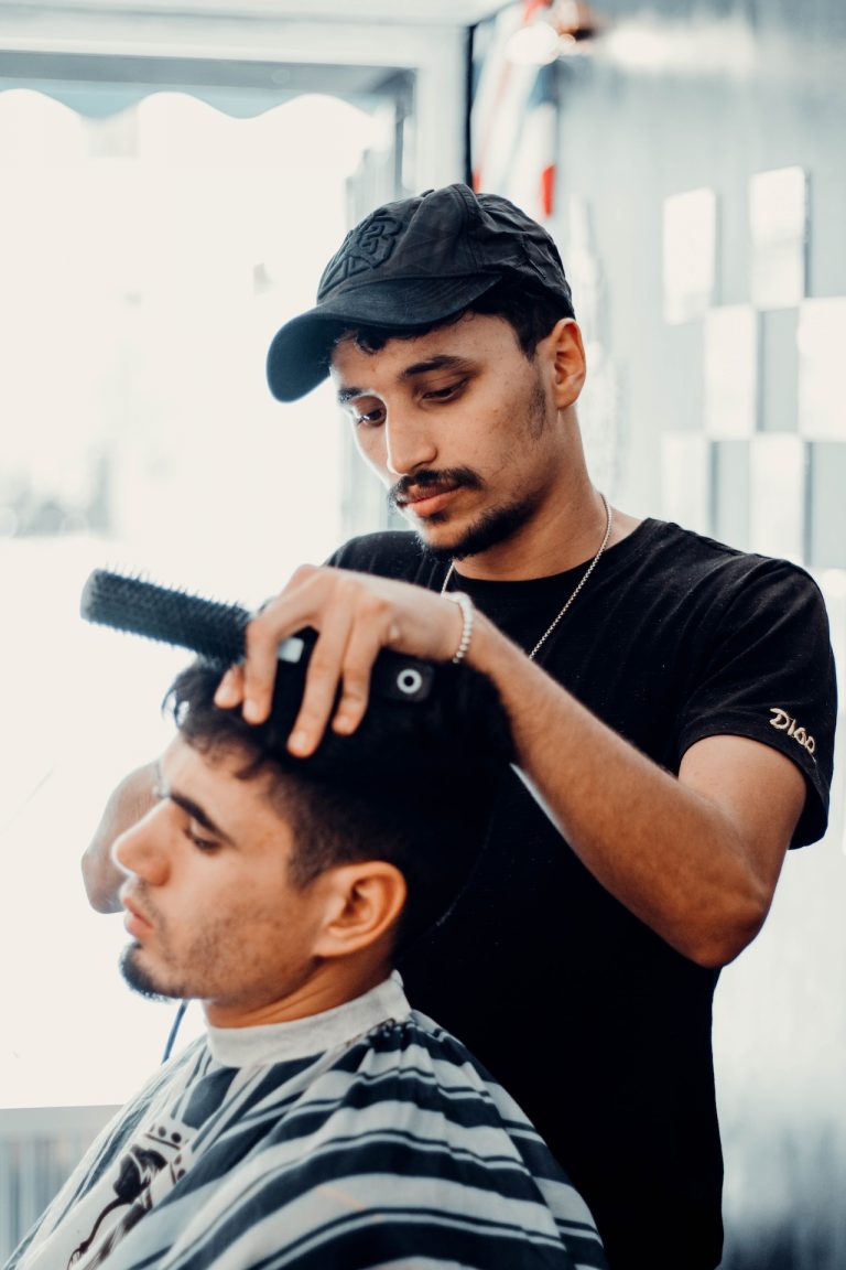 Un barber coupe les cheveux de son client dans son domicile